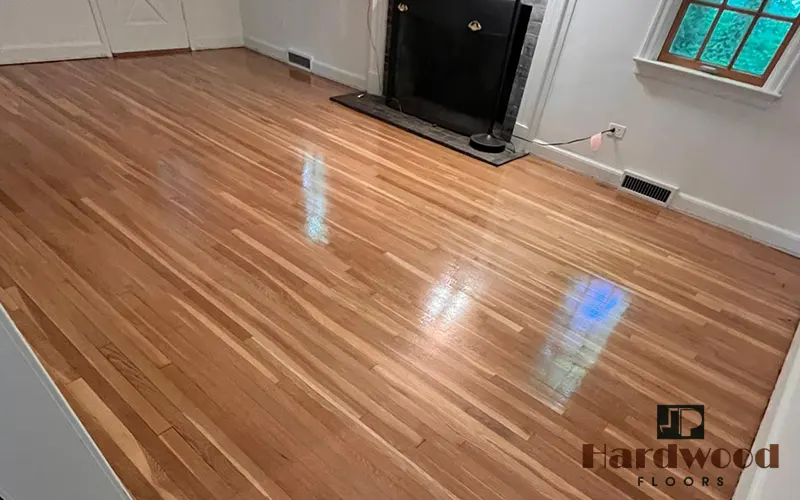 Mirror-smooth high-gloss natural oak strip flooring completed in an empty living area by JP Hardwood Flooring.